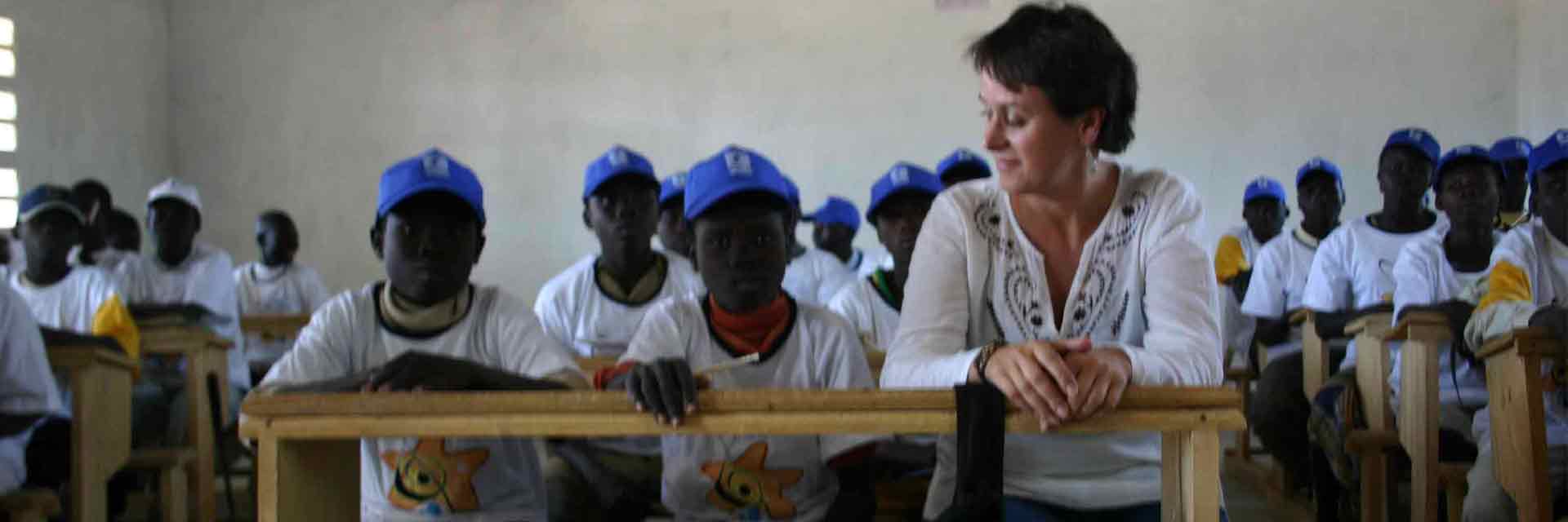 Grupo de niños con una cooperante de Globalmon durante un campamento de verano.