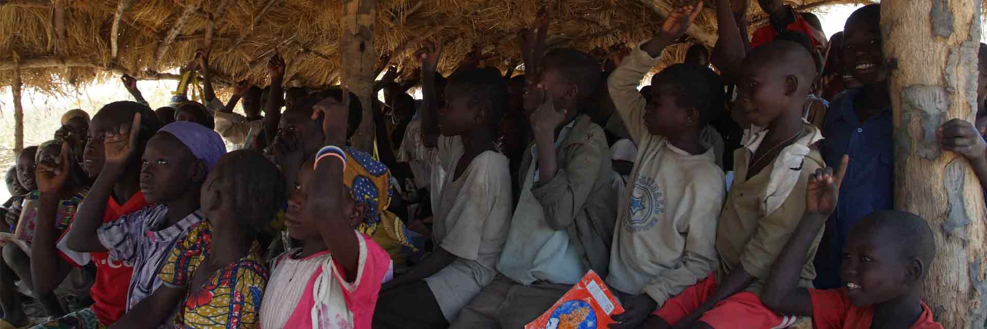 Grupo de niños aisten a una escuela chamizo tradicional